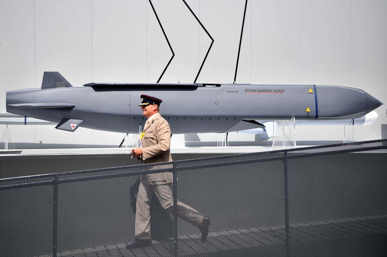 A member of the military walks past a Storm Shadow missile.