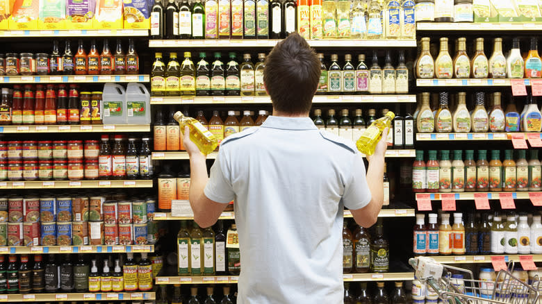 shopper in front of oil shelf