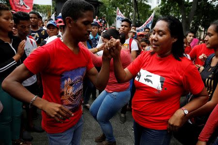 Supporters of Venezuela's President Nicolas Maduro dance as they attend a rally against the application of Organization of American States (OAS) democratic charter, in Caracas, Venezuela June 23, 2016. REUTERS/Marco Bello