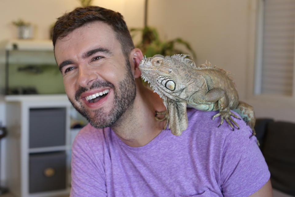 A man with an iguana on his shoulder