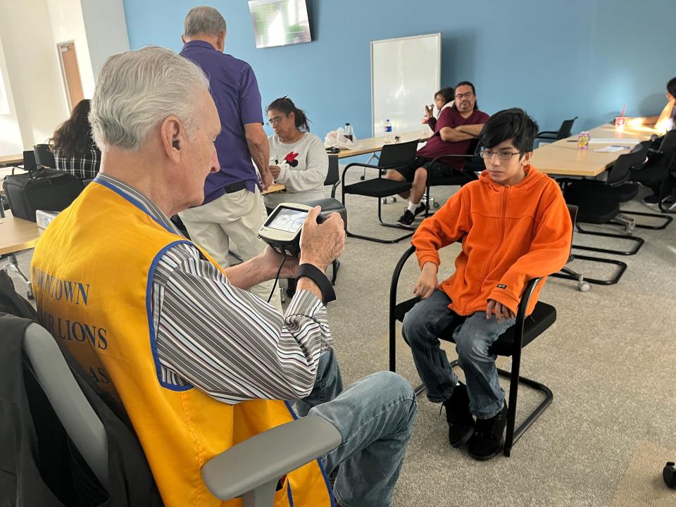 Austin Founder Lions Club member Robert Watson screens Margarito Patina-Trujillo to see if he needs new glasses.