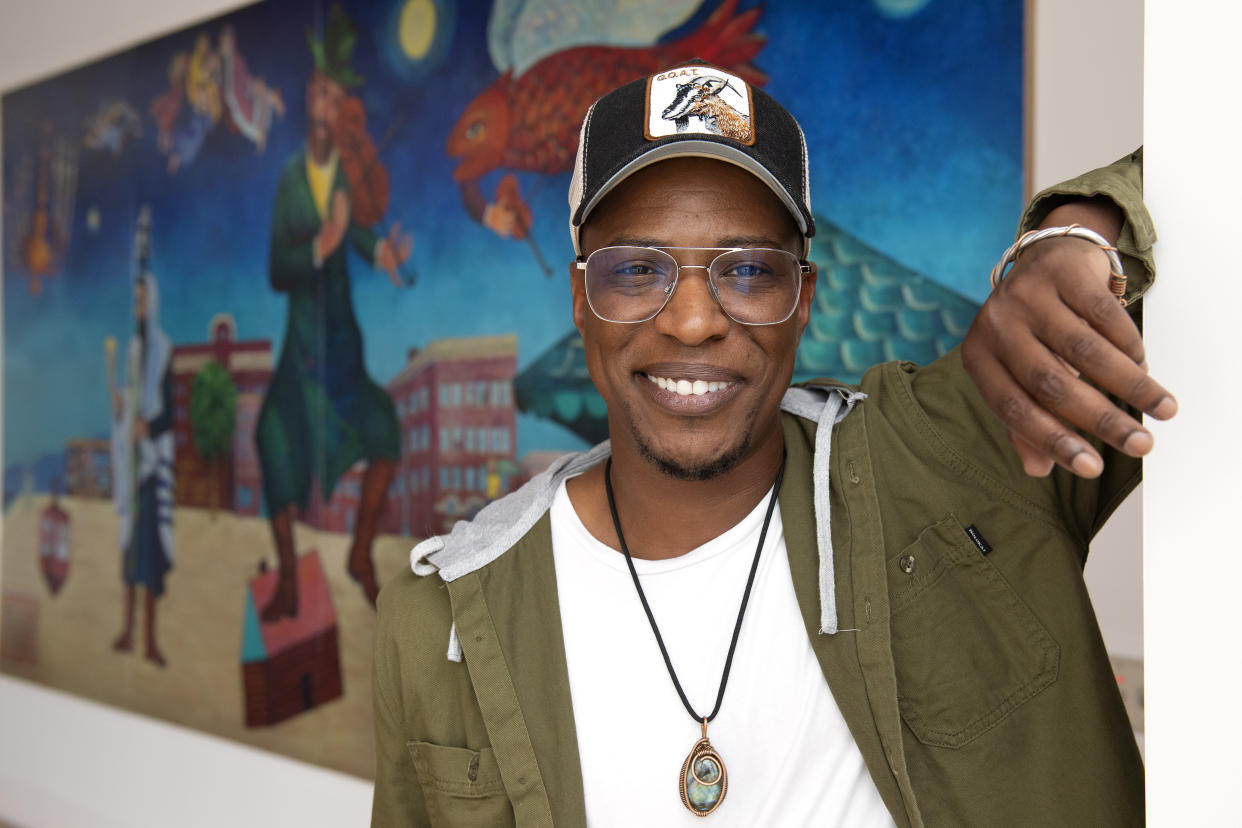 Nate Looney poses in front of a painting at the BAR Center at the Beach Thursday, June 16, 2022, in the Venice section of Los Angeles. Looney is a Black man who grew up in Los Angeles, a descendant of enslaved people from generations ago. He's also an observant, kippah-wearing Jew. (AP Photo/Mark J. Terrill)