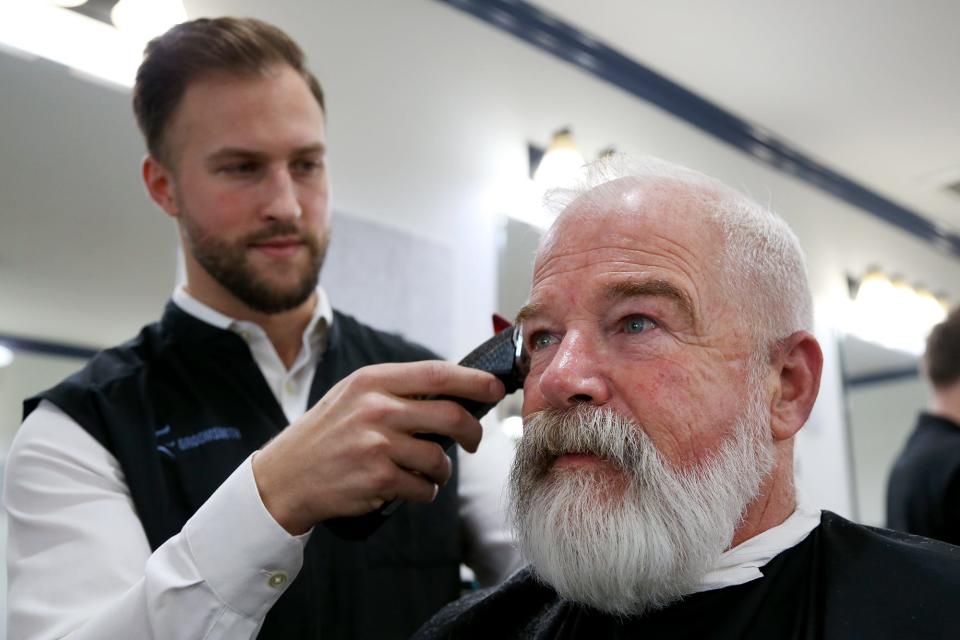 Reed Maerder, owner of The Groomsmith in Portsmouth, gives Bill MacDonald his bi-weekly haircut and beard trim on Tuesday, March 15, 2022.