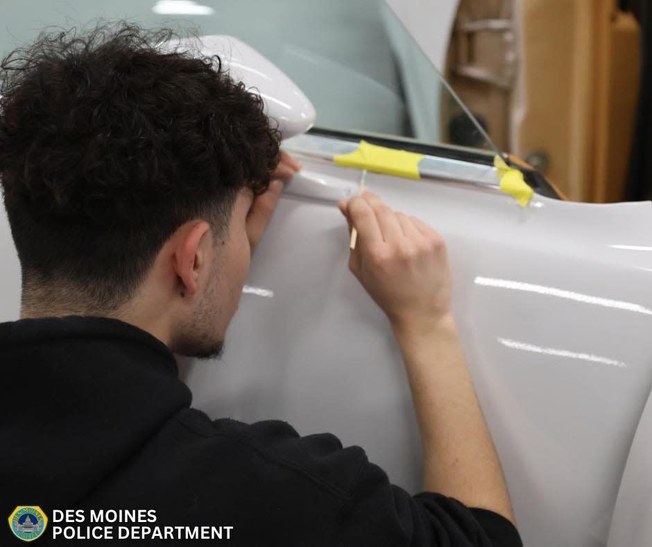 Cristian Villa, senior at Central Campus in Des Moines, completes detail work on a 1978 Ford LTD II his class restored and turned into a replica Des Moines Police Department squad car.