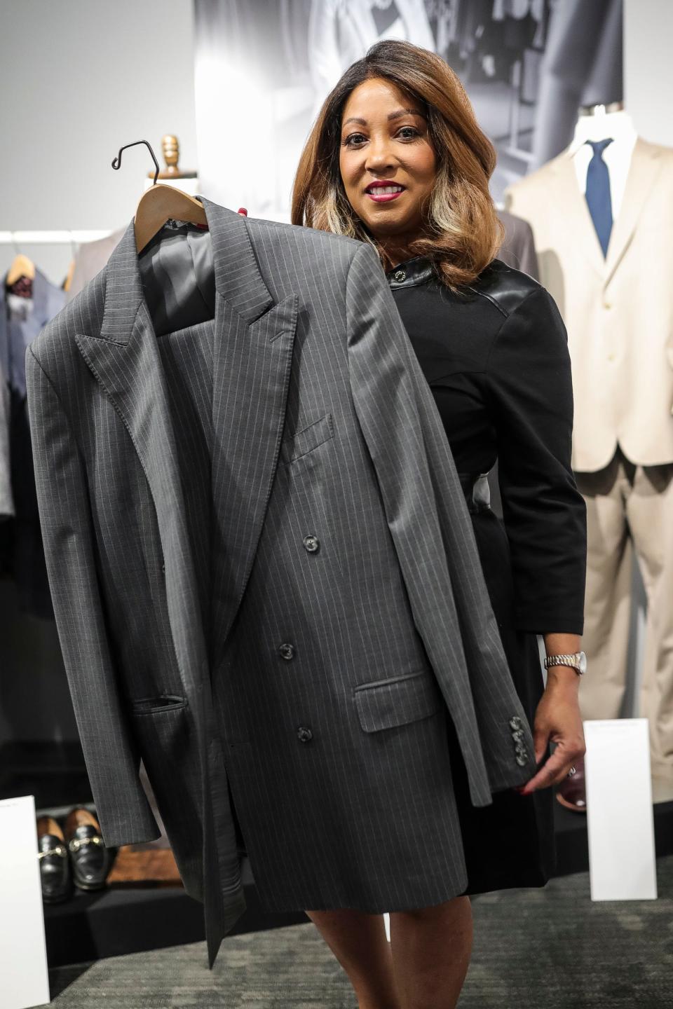 Allison Vaughn, founder and CEO of Jackets for Jobs holds a suit worn by Mayor Dave Bing during the Hustle exhibition at Detroit Historical Museum in Detroit on Wednesday, Nov. 1, 2023.