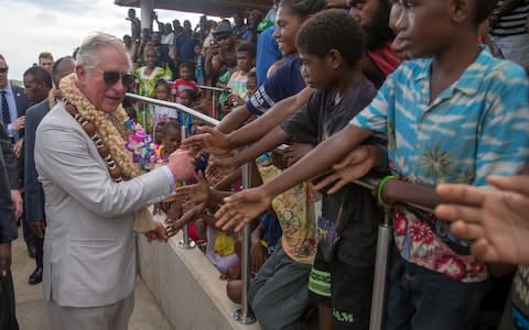 Prince Charles puts on his shades (and some garlands) during his visit to Vanuatu - Credit: Steve Parsons/PA Wire