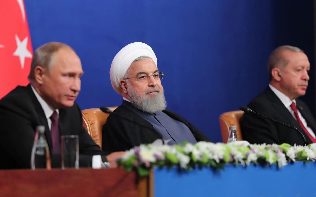 Vladimir Putin gives a press conference with Iranian President Hassan Rouhani and Turkish President Recep Tayyip Erodgan last year - AFP
