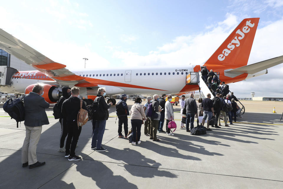 Passengers prepare to board a flight bound for Faro, Portugal, at Gatwick Airport in West Sussex, England after the ban on international leisure travel for people in England was lifted following the further easing of lockdown restrictions, Monday May 17, 2021. (Gareth Fuller/PA via AP)