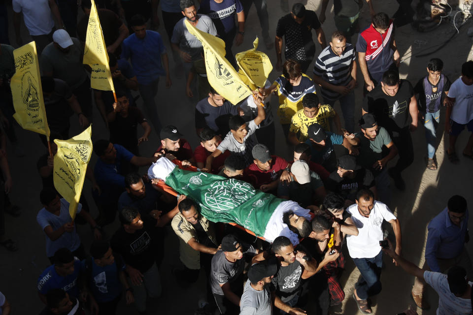 Mourners carry the body of Mohammed Abu Ammar during his funeral along the streets of Bureij refugee camp, central Gaza Strip, Thursday, Sept. 30, 2021. Israeli troops shot and killed Abu Ammar, a 40-year-old Palestinian, on Thursday as he was setting bird traps in the Gaza Strip near the Israeli border, his family said. The military said it was investigating. (AP Photo/Adel Hana)