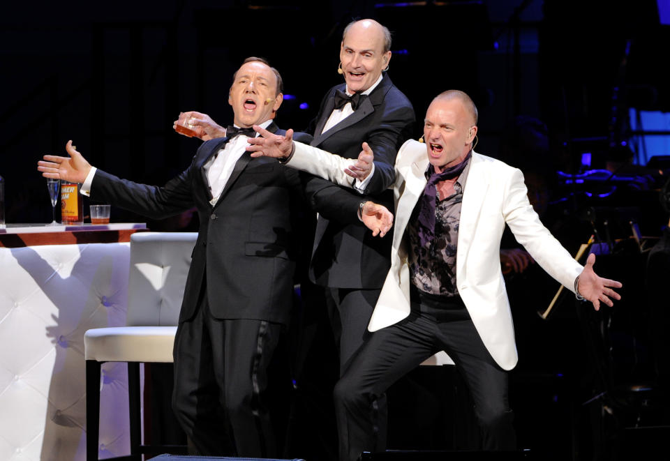 Actor Kevin Spacey, left, performs with singers James Taylor and Sting, right, at the 25th Anniversary Rainforest Fund benefit concert at Carnegie Hall on Thursday, April 17, 2014 in New York. (Photo by Evan Agostini/Invision/AP)