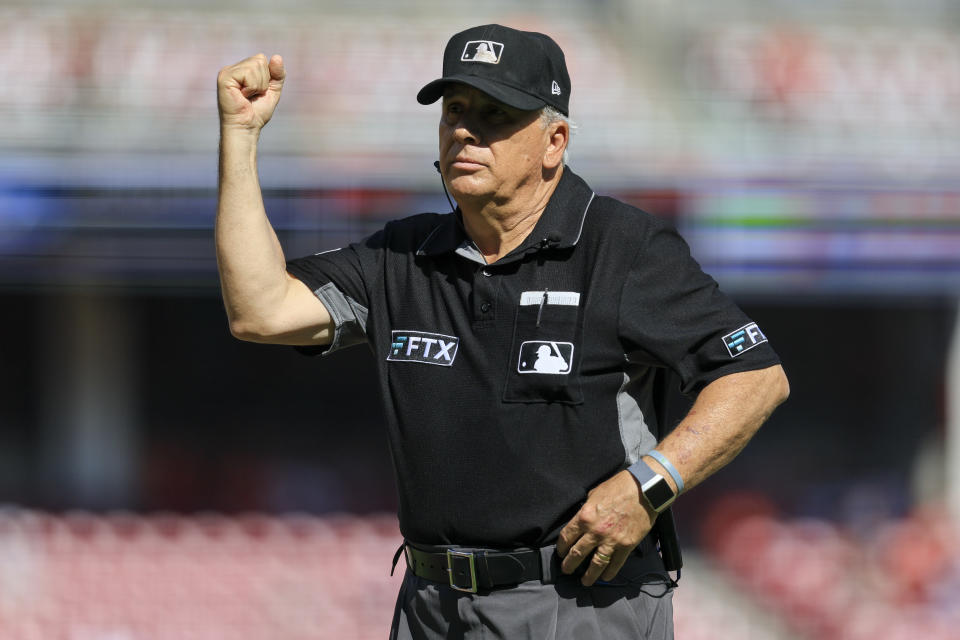 FILE - Major League Baseball umpire Larry Vanover signals an out after a review during a baseball game between the Baltimore Orioles and the Cincinnati Reds in Cincinnati, Sunday, July 31, 2022. Vanover remained hospitalized Thursday, April 13, 2023, after being hit in the head with a relay throw during Wednesday's game between the New York Yankees and Cleveland Guardians. (AP Photo/Aaron Doster, File)