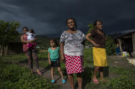 Residents gather for a community meeting under threatening skies in Hacienda Uno, Honduras, Friday, June 25, 2021, near El Espiritu, an area historically controlled by the Valle family drug traffickers. (AP Photo/Rodrigo Abd)