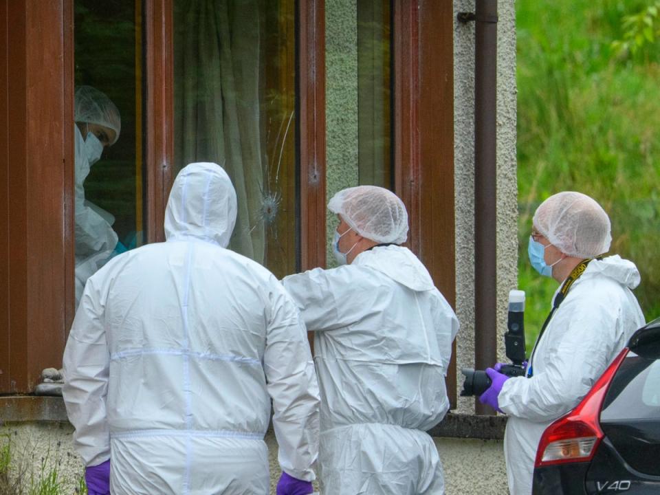 Forensics officers at the scene of an incident at a property in the Dornie area of Wester Ross, on the northwest coast of Scotland (PA)