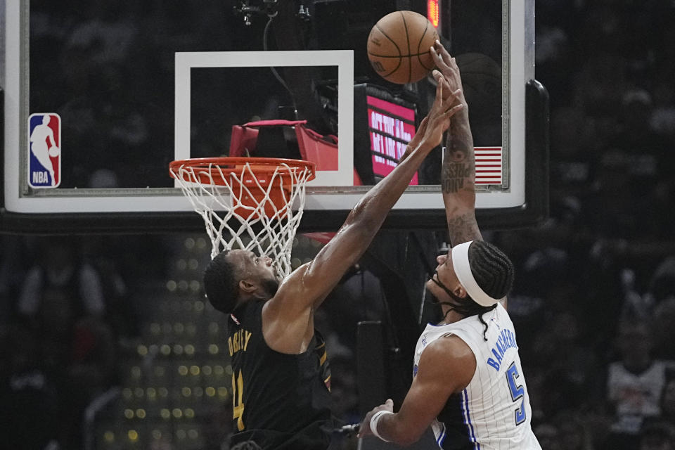 Orlando Magic forward Paolo Banchero (5) is fouled by Cleveland Cavaliers forward Evan Mobley (4) in the first half of Game 7 of an NBA basketball first-round playoff series Sunday, May 5, 2024, in Cleveland. (AP Photo/Sue Ogrocki)