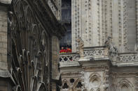 Dos bomberos conversan en un balcón de la catedral de Notre Dame, el martes 16 de abril de 2019 en París. (AP Foto/Francois Mori)