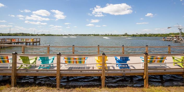 Lounge chairs on a deck looking over a lake.