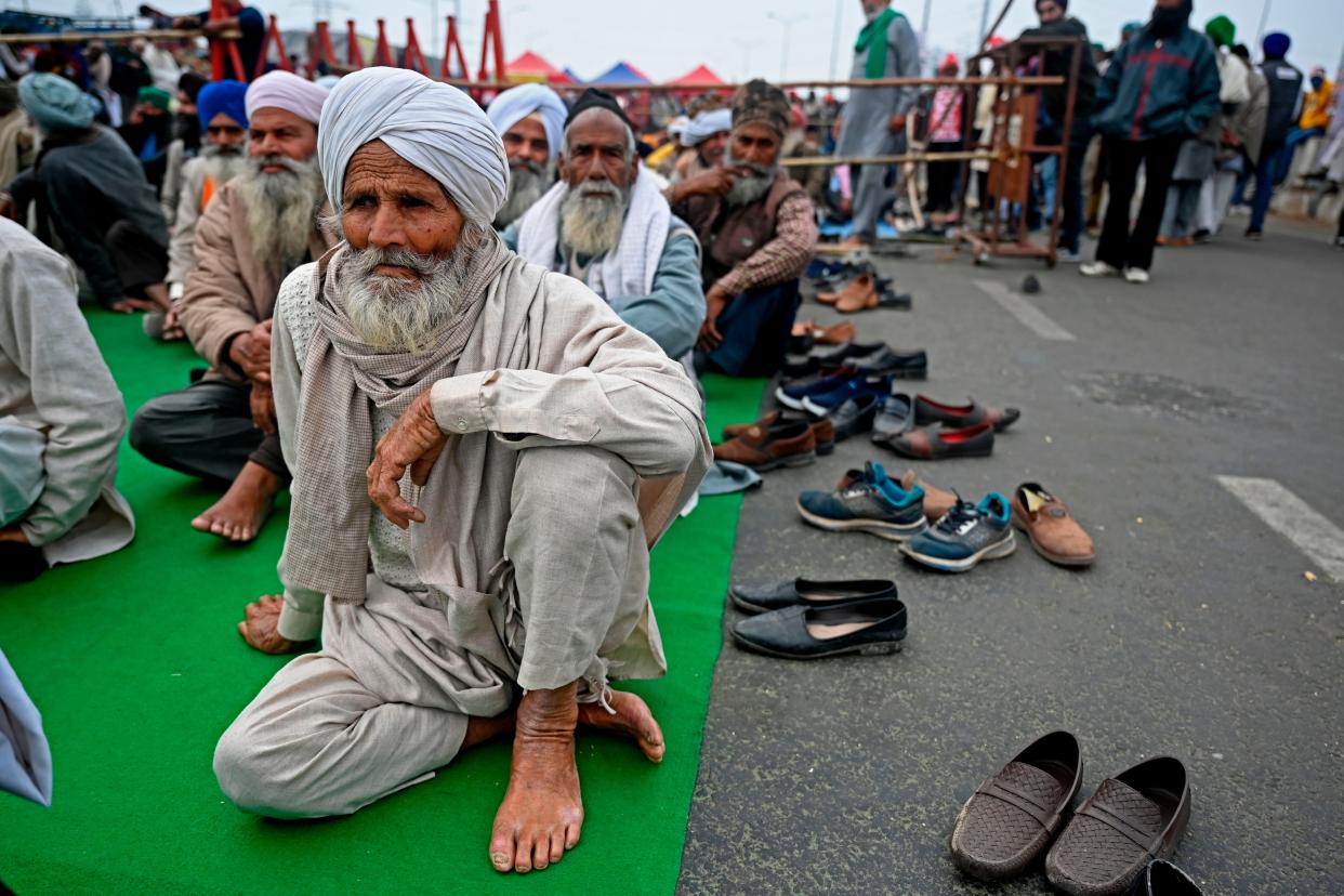 <p>Farmers sit along a blocked highway as they continue to protest against the central government's recent agricultural reforms at the Delhi-Uttar Pradesh state border in Ghazipur on 18 January 2021</p> (AFP via Getty Images)