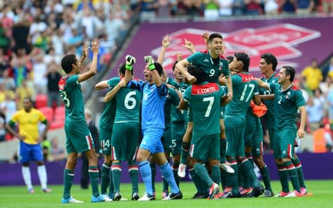 Mexico's forward Oribe Peralta (top, C) ...Mexico's forward Oribe Peralta (top, C) is carried by Mexico's midfielder Javier Cortes as the players celebrate winning the men's football final match between Brazil and Mexico at Wembley stadium in London during the London Olympic Games  - Credit: Getty images