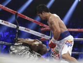 Manny Pacquiao, right, of the Philippines, drives Timothy Bradley down into the ropes in their WBO welterweight title boxing bout Saturday, April 12, 2014, in Las Vegas. (AP Photo/Isaac Brekken)