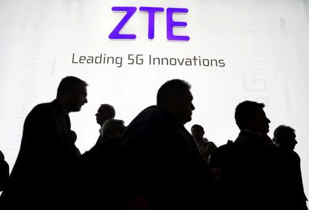 Visitors pass in front of the Chinese telecoms equipment group ZTE Corp booth at the Mobile World Congress in Barcelona, Spain, February 26, 2018. REUTERS/Sergio Perez/Files