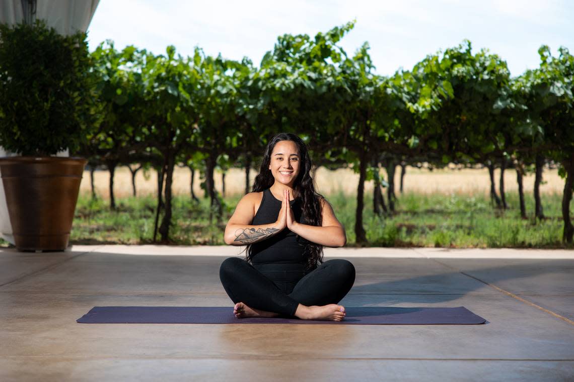 Registered yoga teacher Kathryn Luna sits cross-legged on a yoga mat at Scribner Bend Vineyards at 9051 River Road in Sacramento County. The Sacramento resident teaches outdoor yoga classes at the vineyard through Aug. 25.