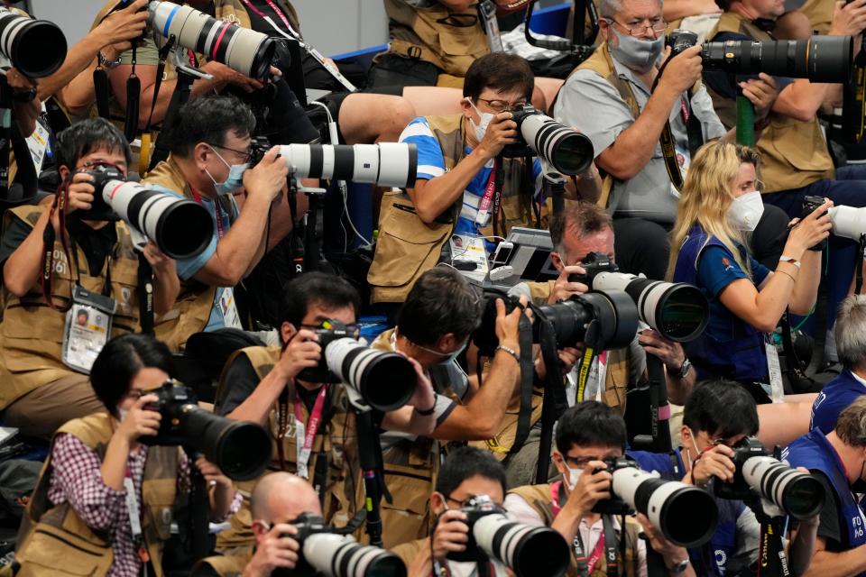 Photographers work during the evening session of the first night of swimming competition during the Tokyo 2020 Olympic Summer Games at Tokyo Aquatics Centre on July 24, 2021. 