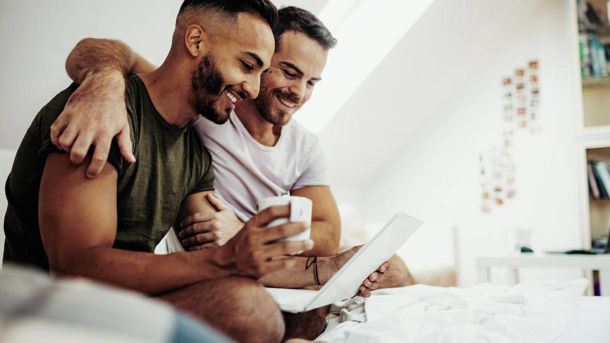 Gay couple at home in penthouse.