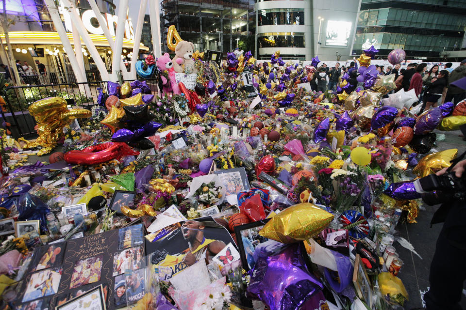 Fans gather at a memorial for the late Kobe Bryant in front of Staples Center in Los Angeles, Sunday, Feb. 2, 2020. Bryant, the 18-time NBA All-Star who won five championships and became one of the greatest basketball players of his generation during a 20-year career with the Lakers, died in a helicopter crash Sunday, Jan. 26. (AP Photo/Damian Dovarganes)