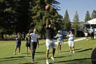 Phil Mickelson shoots a basketball below the 17th green of the Silverado Resort North Course as Stephen Curry looks on during the pro-am at the Safeway Open PGA golf tournament Wednesday, Sept. 25, 2019, in Napa, Calif. (AP Photo/Eric Risberg)