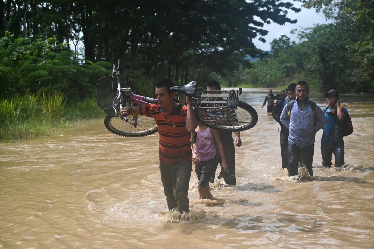 Des habitants marchent dans l'eau après le passage de l'ouragan Eta - Johan ORDONEZ - AFP