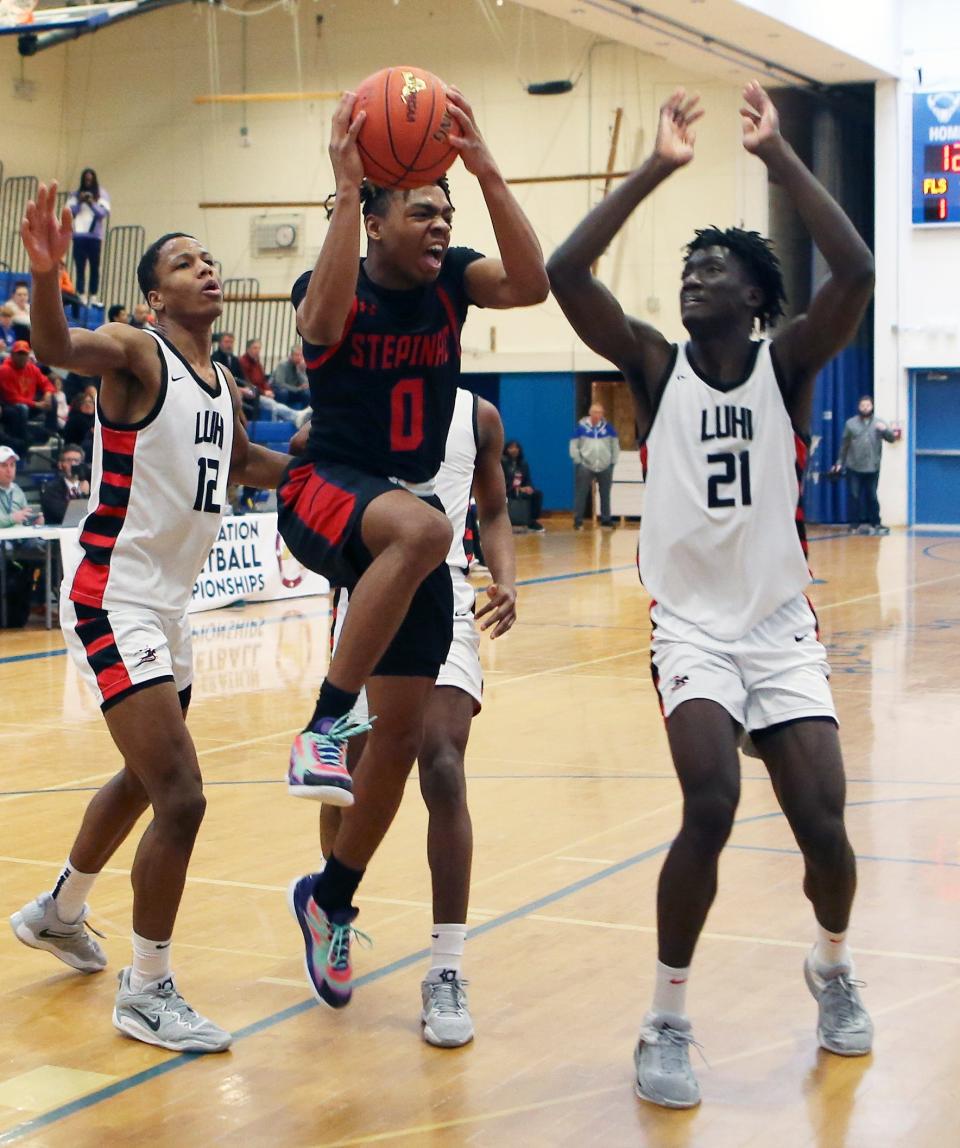 Stepinac's Danny Carbuccia (0) tries to get around Long Island Lutheran's Ben Michaels (12) and Godswill Erheriene (21) during the New York State Federation Tournament championship at Shaker High School in Latham March 26, 2023. 