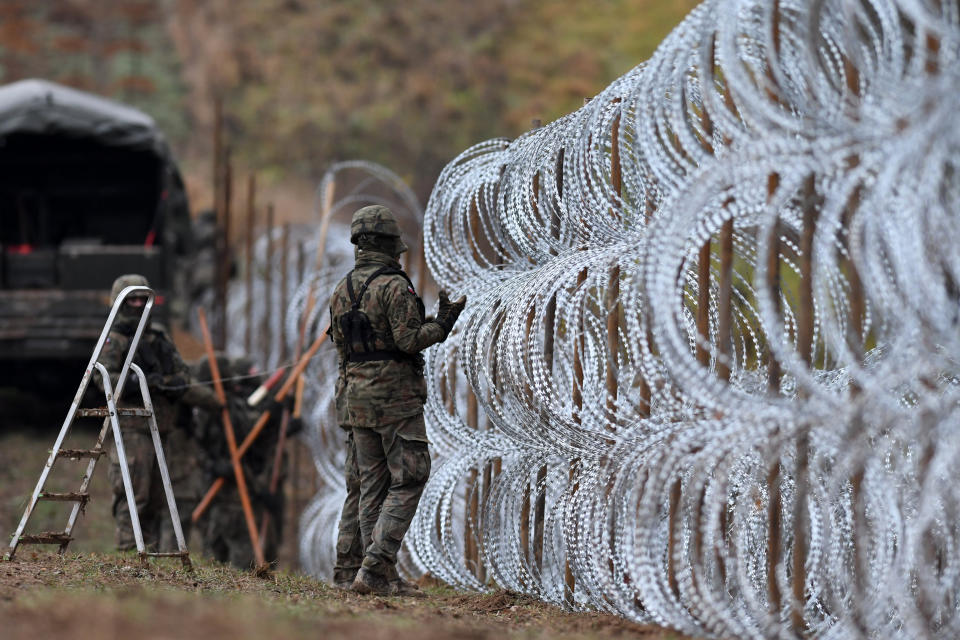 Polish soldiers begin laying a razor wire barrier along Poland’s border with the Russian exclave of Kaliningrad in Wisztyniec, Poland, on Wednesday Nov. 2, 2022. Poland’s government ordered the construction of the barrier after Russia’s aviation authority decided to launch flights from the Middle East and North Africa to Kaliningrad. The Polish government said it was acting to prevent a migration crisis at that border. (AP Photo/Michal Kosc)