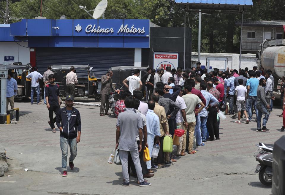 Kashmiri residents queue up at a fuel station in Srinagar, India, Sunday, Aug. 4, 2019. People in Srinagar and other towns in Indian kashmir thronged grocery stores and medical shops to stock up on essentials. Tensions have soared along the volatile, highly militarized frontier between India and Pakistan in the disputed Himalayan region of Kashmir as India deployed more troops and ordered thousands of visitors out of the region. (AP Photo/Mukhtar Khan)