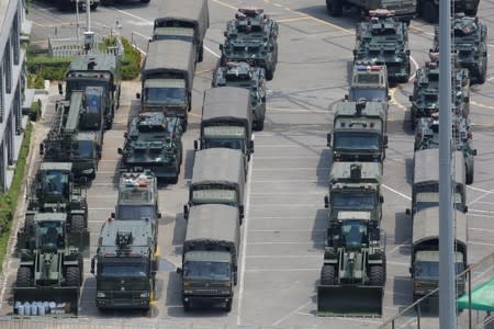 Military vehicles are parked on the grounds of the Shenzhen Bay Sports Center in Shenzhen