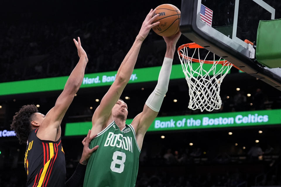 Boston Celtics center Kristaps Porzingis (8) gets past Atlanta Hawks forward Jalen Johnson, left, on a drive to the basket during the first half of an NBA basketball game Wednesday, Feb. 7, 2024, in Boston. (AP Photo/Charles Krupa)