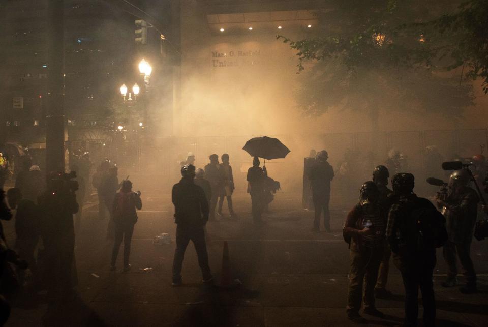 Protesters are surrounded by tear gas near the Mark O. Hatfield federal courthouse in downtown Portland as protesters take part in a rally against police brutality in Portland, Oregon late on July 24, 2020.  / Credit: KATHRYN ELSESSER/AFP via Getty Images