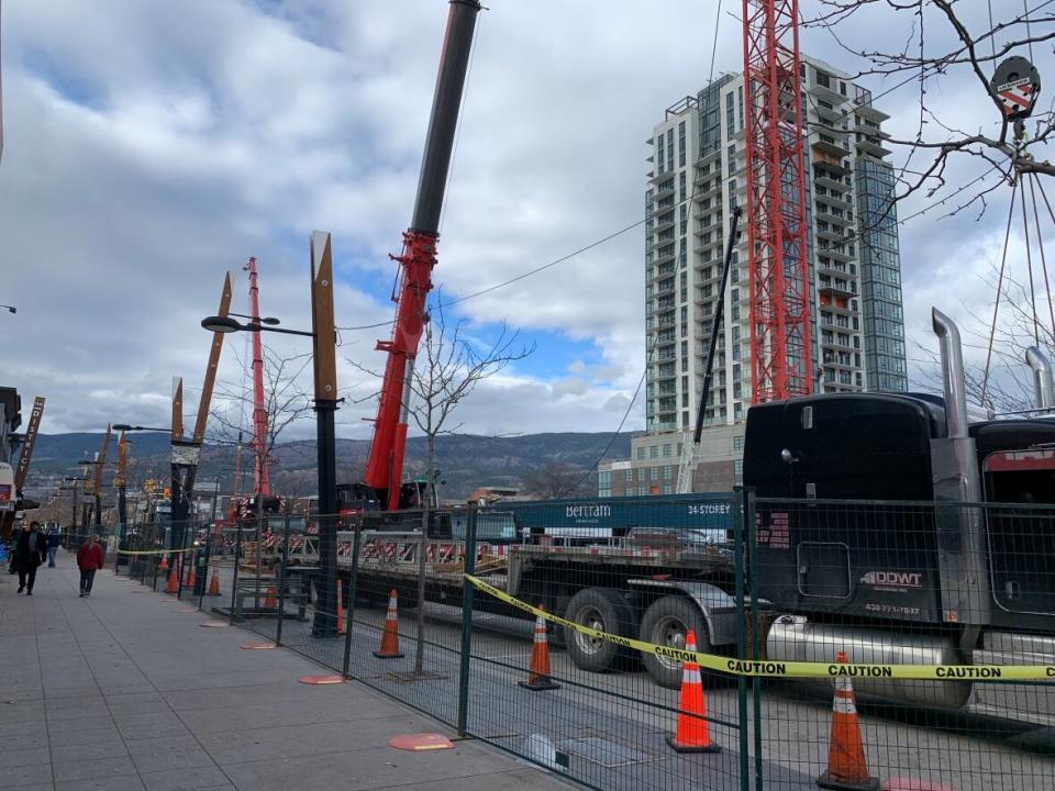 A part of Bernard Avenue in downtown Kelowna, B.C., is closed as cranes are being reassembled near Mission Group's construction site on Oct. 26, 2021. (Winston Szeto/CBC - image credit)