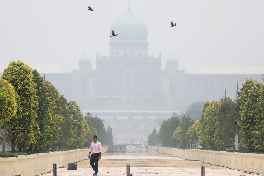 A man passes by the Prime Minister’s Office, which is shrouded in haze, in Putrajaya September 23, 2019. — Reuters pic