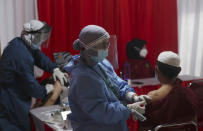 Residents receive shots of the AstraZeneca vaccine during a coronavirus vaccination campaign in Bekasi on the outskirts of Jakarta, Indonesia, Thursday, June 17, 2021. (AP Photo/Achmad Ibrahim)