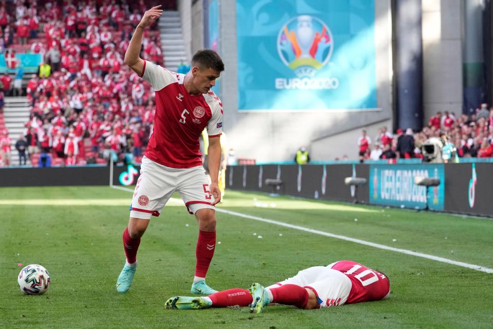 Denmark's Joakim Maehle reacts as teammate Christian Eriksen lies on the pitch after collapsing during the Euro 2020 soccer championship group B match against Finland.