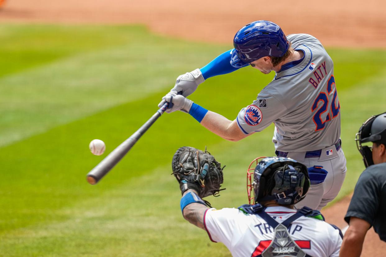 New York Mets third baseman Brett Baty (22) singles to drive in a run against the Atlanta Braves during the first inning on April 11, 2024, at Truist Park.