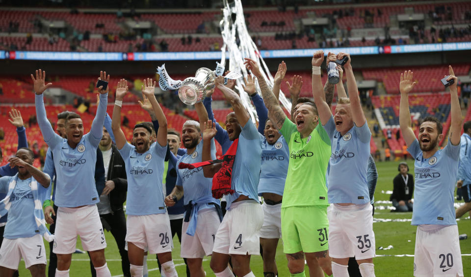 Manchester City's Vincent Kompany lifts the trophy as celebrates with his teammates after winning the English FA Cup Final soccer match between Manchester City and Watford at Wembley stadium in London, Saturday, May 18, 2019. Manchester City won 6-0. (AP Photo/Tim Ireland)