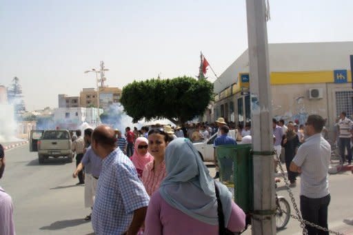 People look on as clouds of tear gas rise in a street in Sidi Bouzid, August 9. Police fired tear gas and rubber bullets to disperse a second anti-government protest in the central Tunisian town of Sidi Bouzid, birthplace of last year's revolution