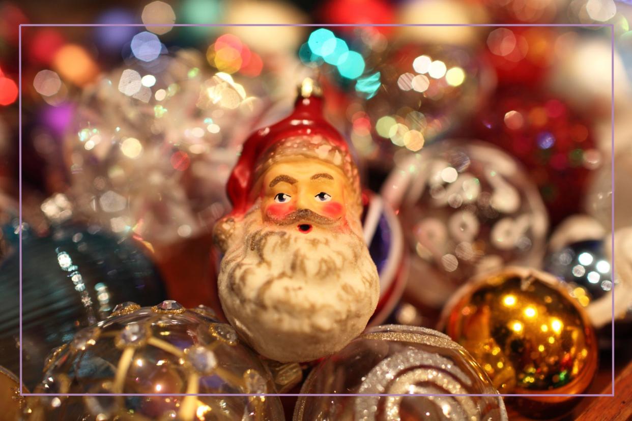  Is Santa Claus real? illustrated by a Father Christmas decoration sat on pile of decorations. 