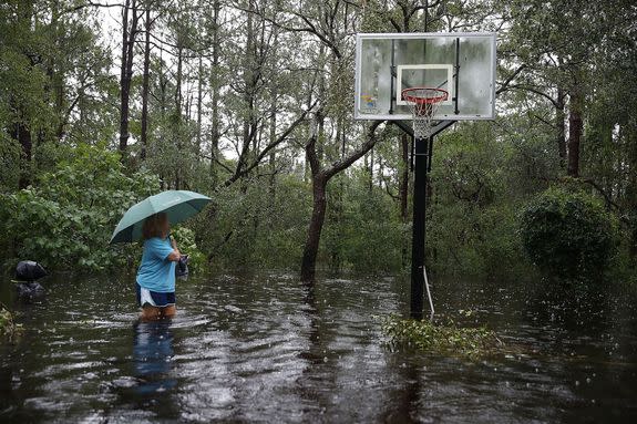 Kim Adams wades through waist-deep floodwaters at her home in Southport, North Carolina.