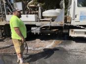 Driller Shane Harris checks the water pressure from a well that he had just drilled at the home of Linda and Rodger Jincks in La Pine, Ore., on Aug. 26, 2021. (AP Photo/Andrew Selsky)