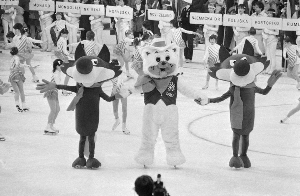 Vucko the wolf, the symbol for the XIV winter Olympic Games in Sarajevo's Yugoslavia, dances with Howdy the bear who will be the symbol for the next Winter Games, to be held on Calgary, Alberta, Feb. 19, 1984, at the closing ceremonies for the games in Sarajevo. (AP Photo)