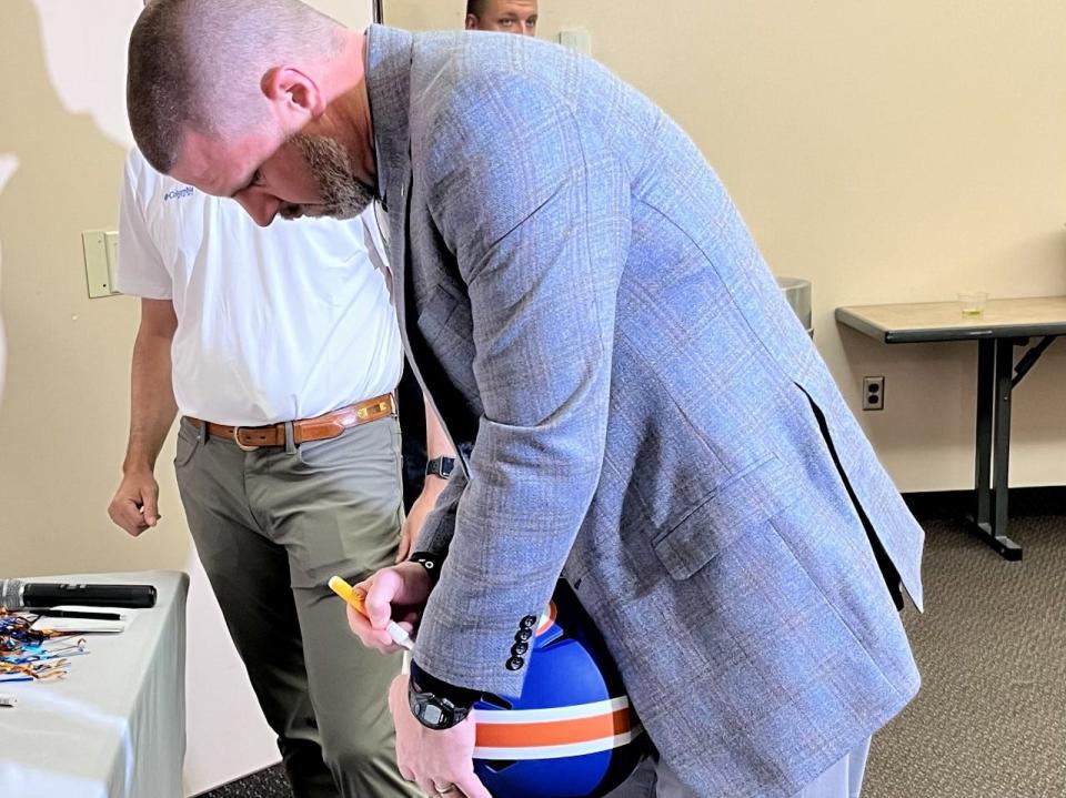 Florida football coach Billy Napier signs a Gator helmet during his visit to the Clay County Gator Club on Monday at the Thrasher-Horne Center.