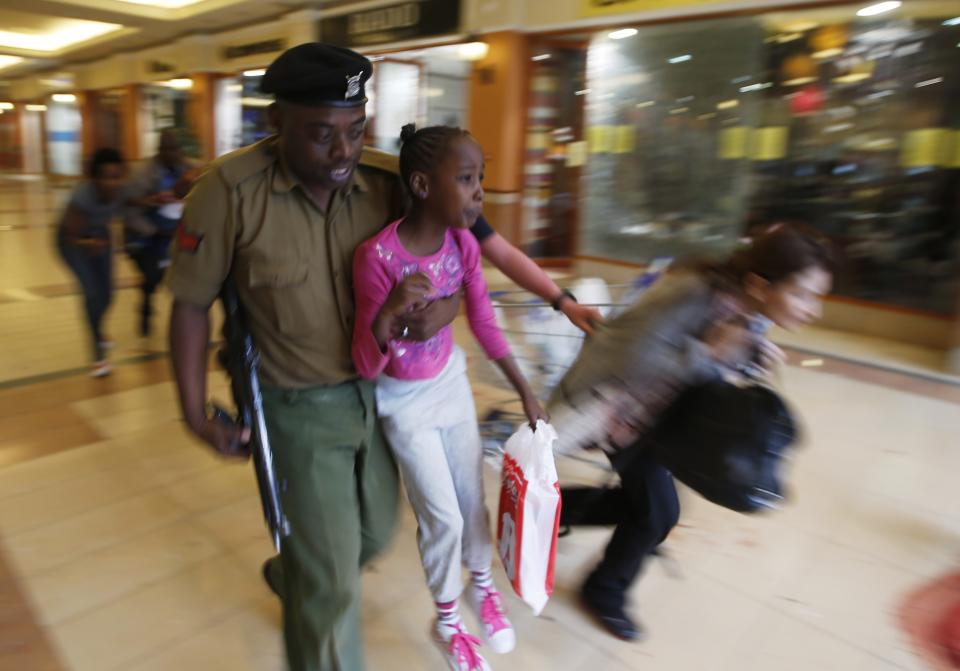 A soldier carries a child to safety as armed police hunt gunmen who went on a shooting spree at Westgate shopping centre in Nairobi