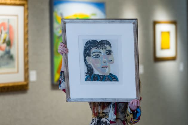 A staff member holds an aquatint and drypoint in colors titled 